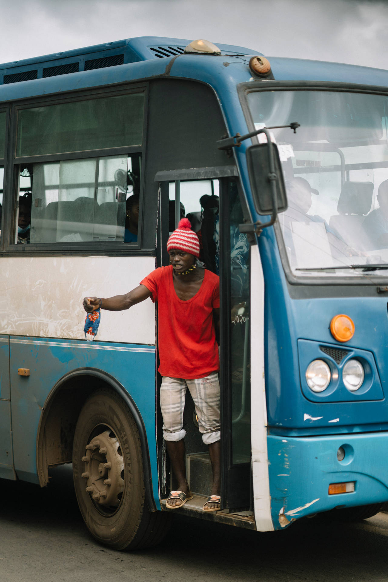 Conductor By The Bus Door In Sierra Leone Background