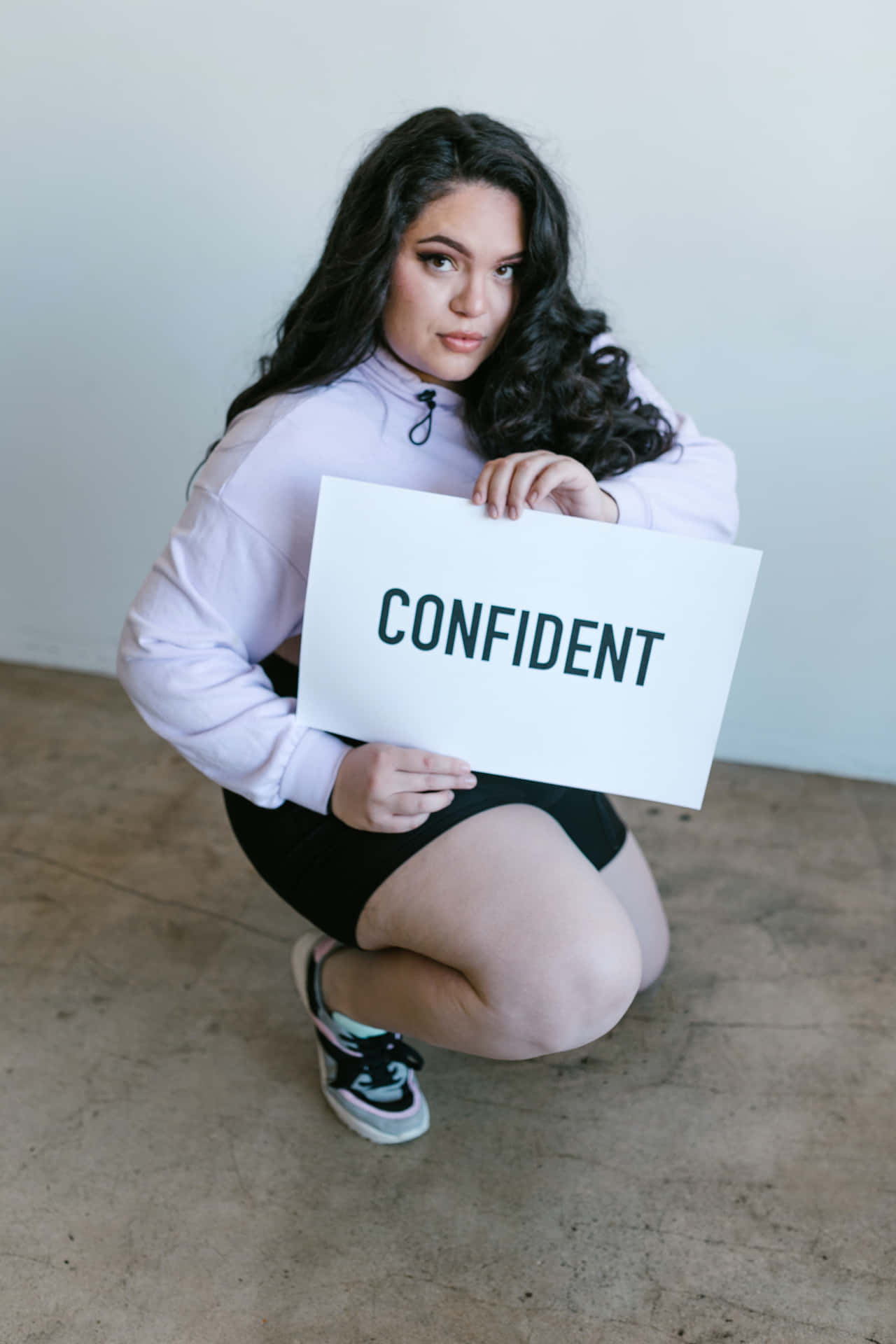 Confidence Unleashed: A Curvy Woman With A Confident Sign Background