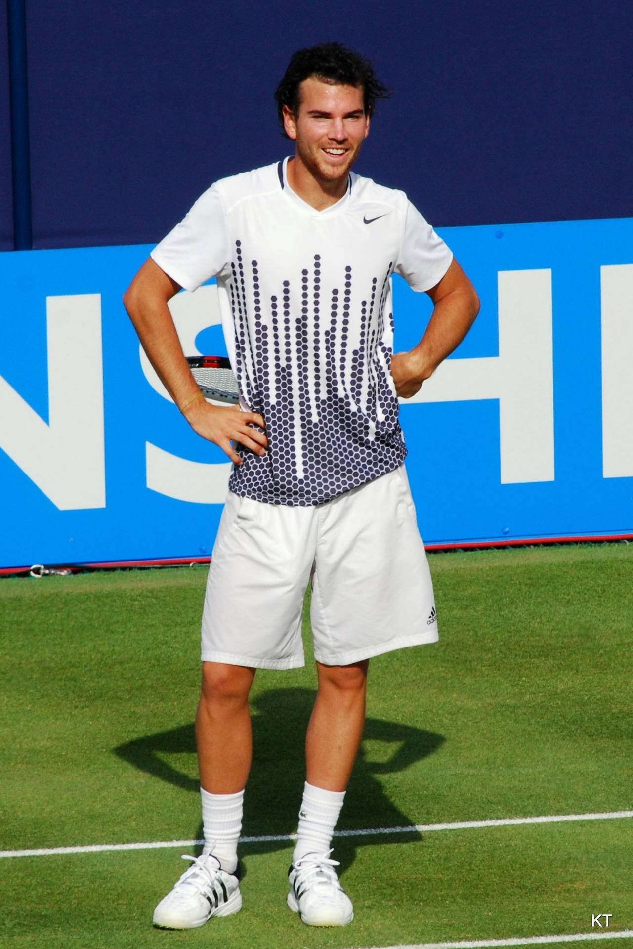 Confident Adrian Mannarino With Hands On Waist Background