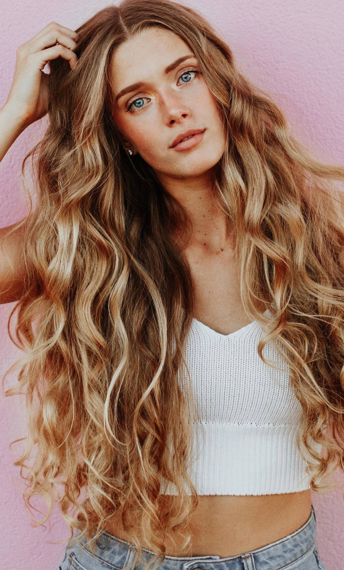 Confident Blonde Woman Flaunting Her Gorgeous Curly Hair Background