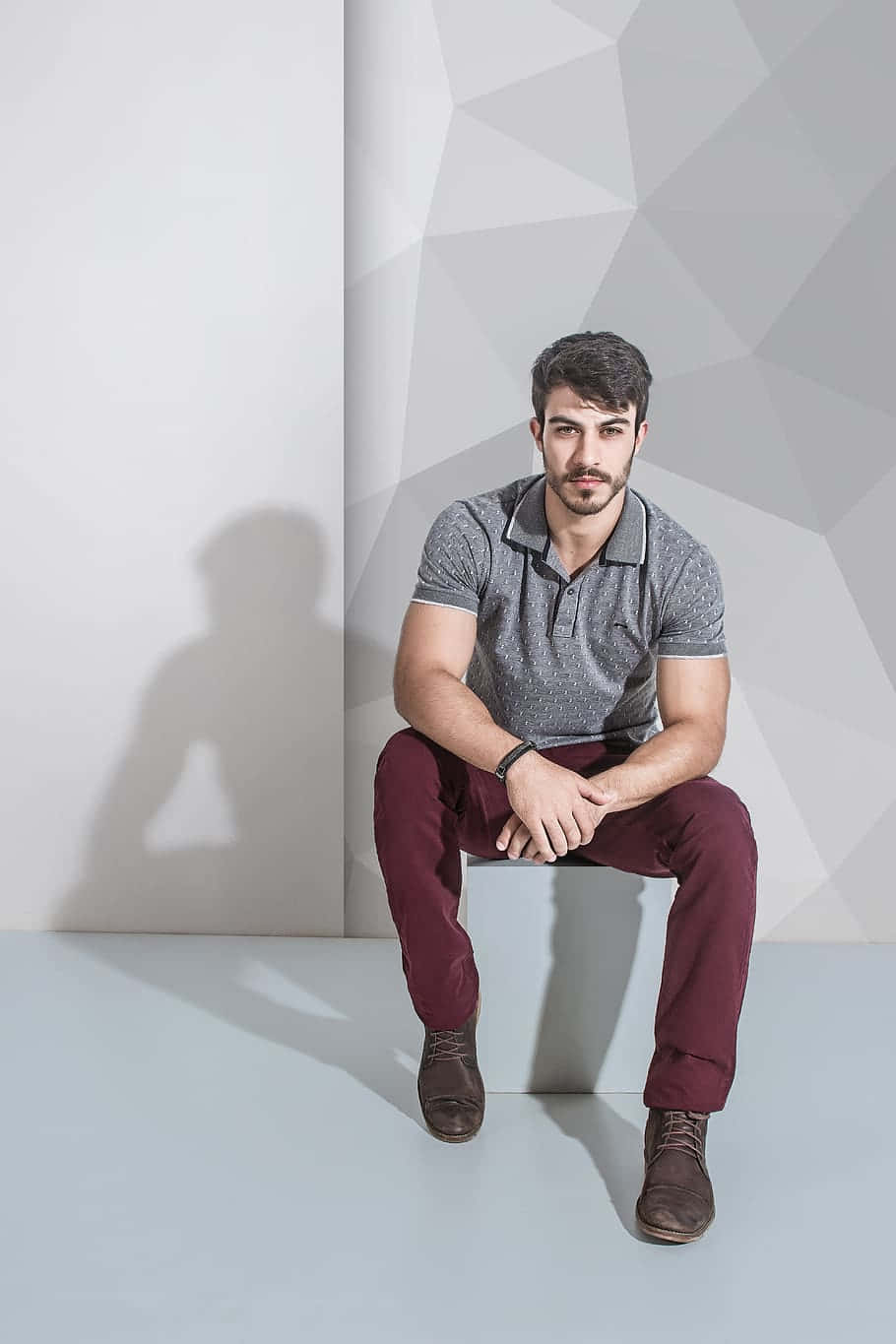 Confident Male Model Posing Against Abstract Gray Wall