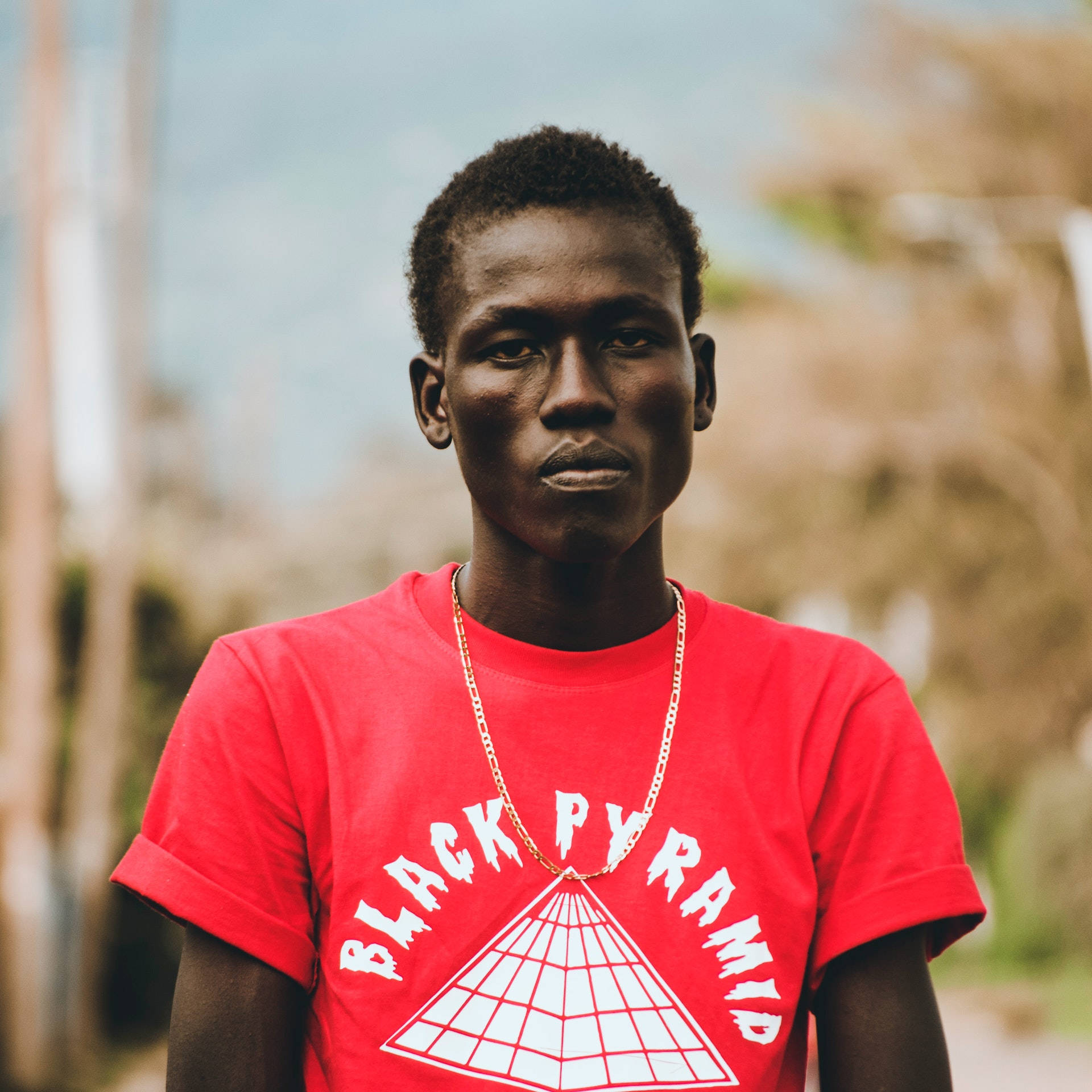 Confident Man In Black Pyramid Shirt Background