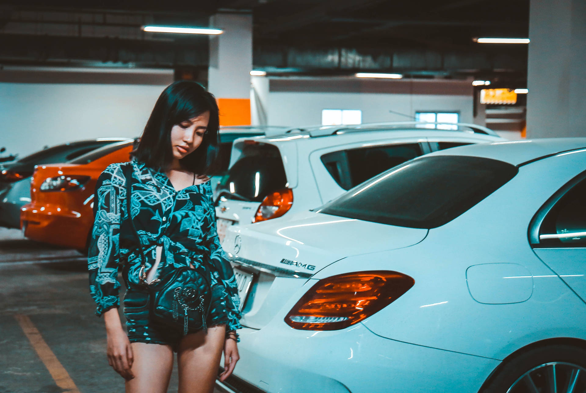 Confident Woman Posing In A Spacious Parking Lot Background