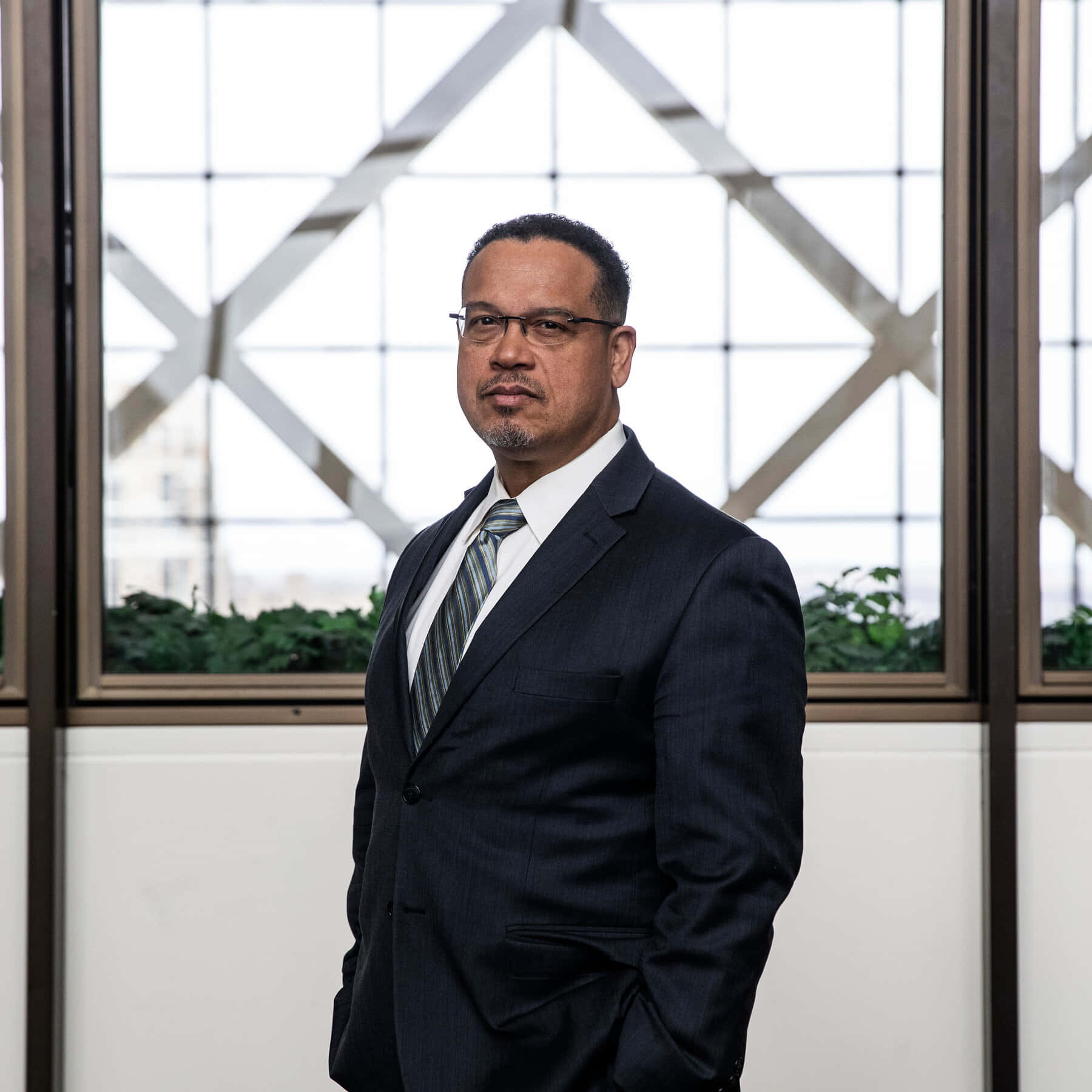 Congressman Keith Ellison Reflects Near Glass Windows Background
