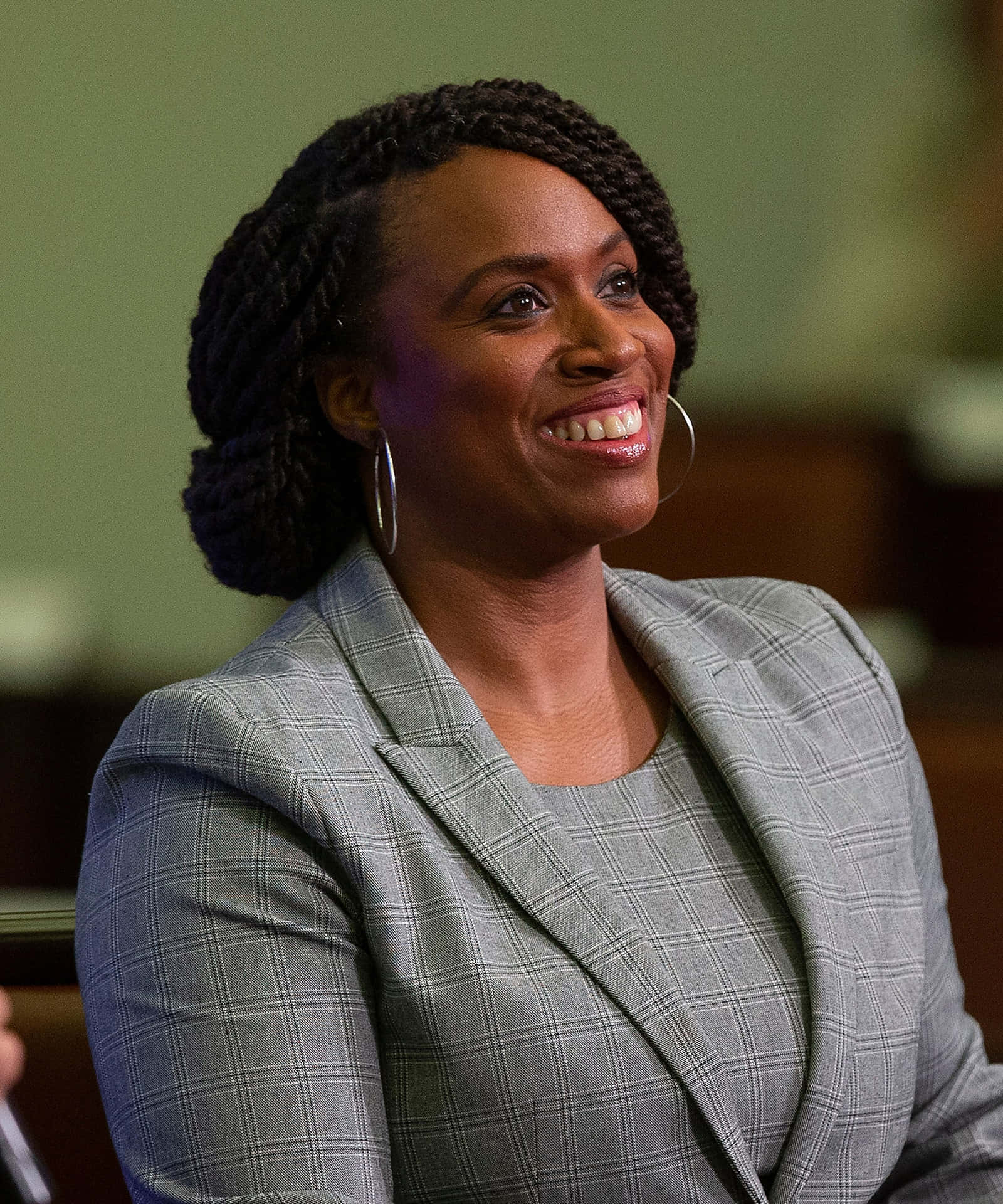 Congresswoman Ayanna Pressley Smiling In Gray Pantsuit Background