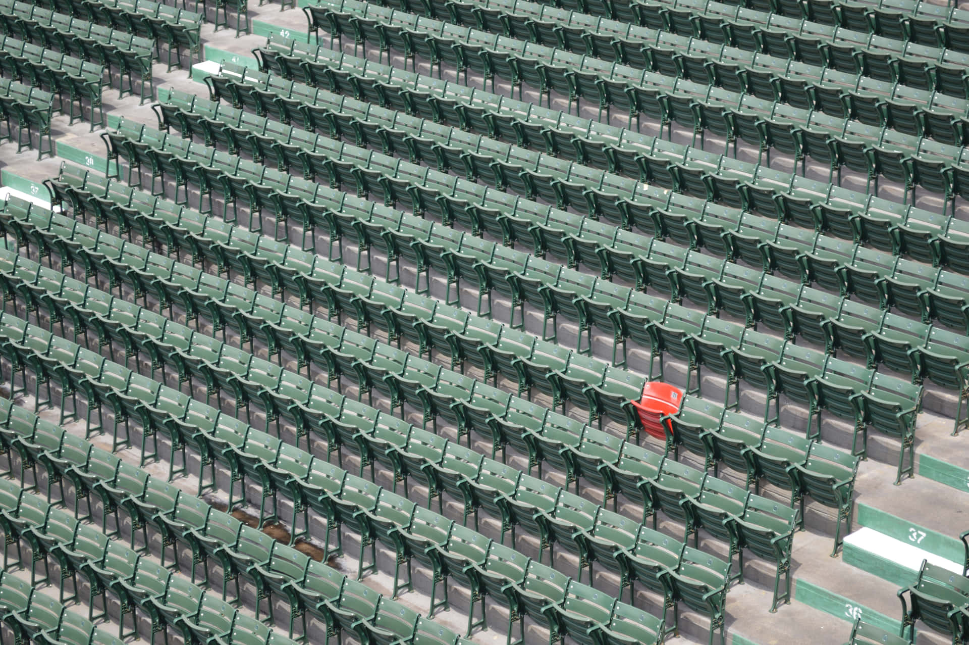 Conspicuous Red Chair In A Row Of Green Chairs Background