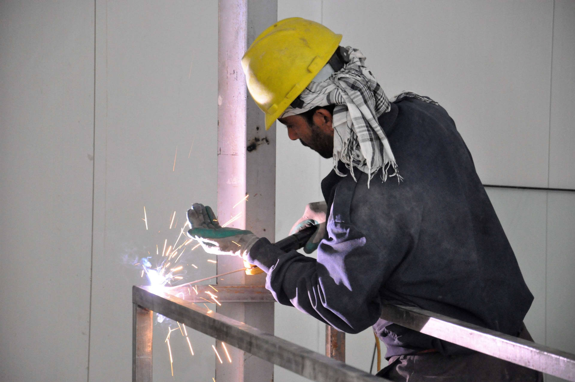 Construction Worker Welding A Steel Background