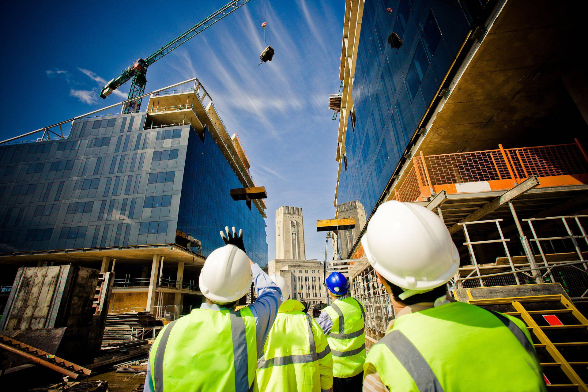 Construction Workers Looking Up At Crane Background