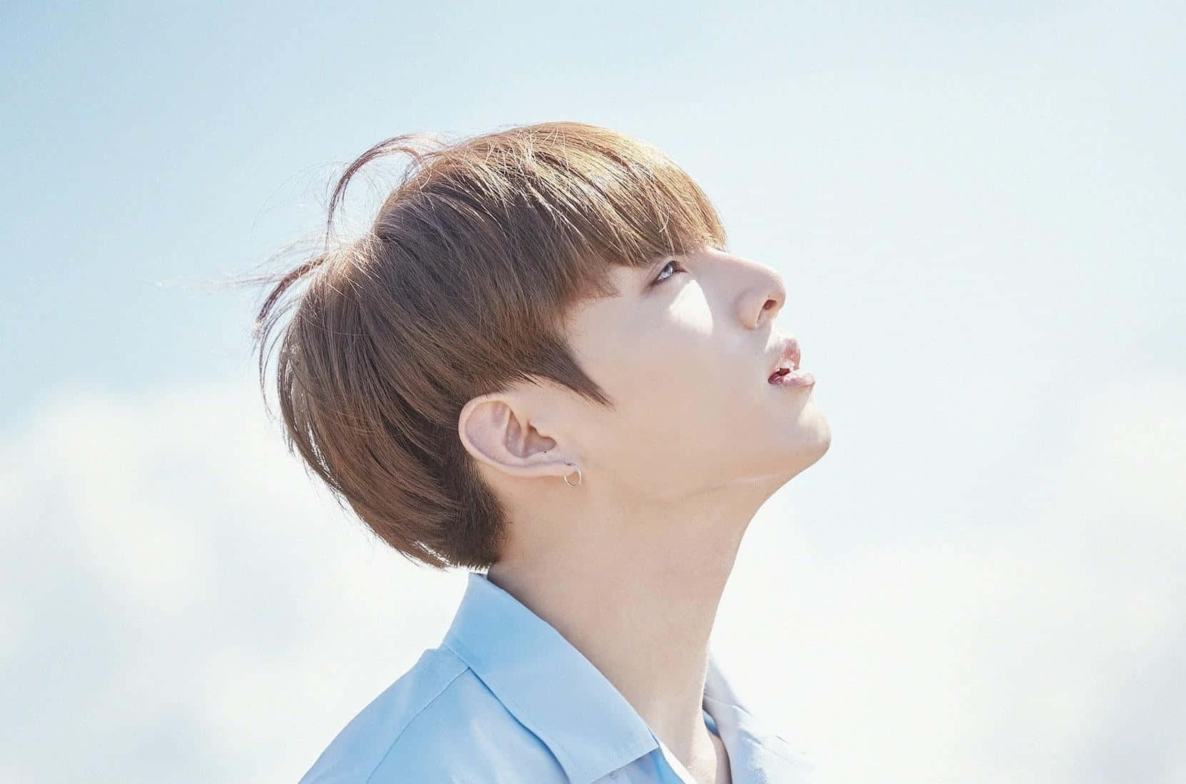 Contemplative Gaze Against Blue Sky Background