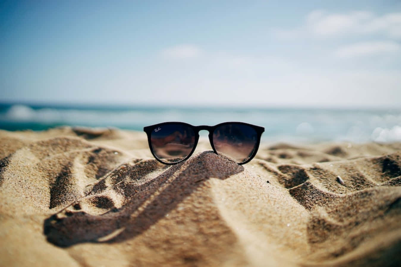 Cool Summer Sunglasses On The Sand Background