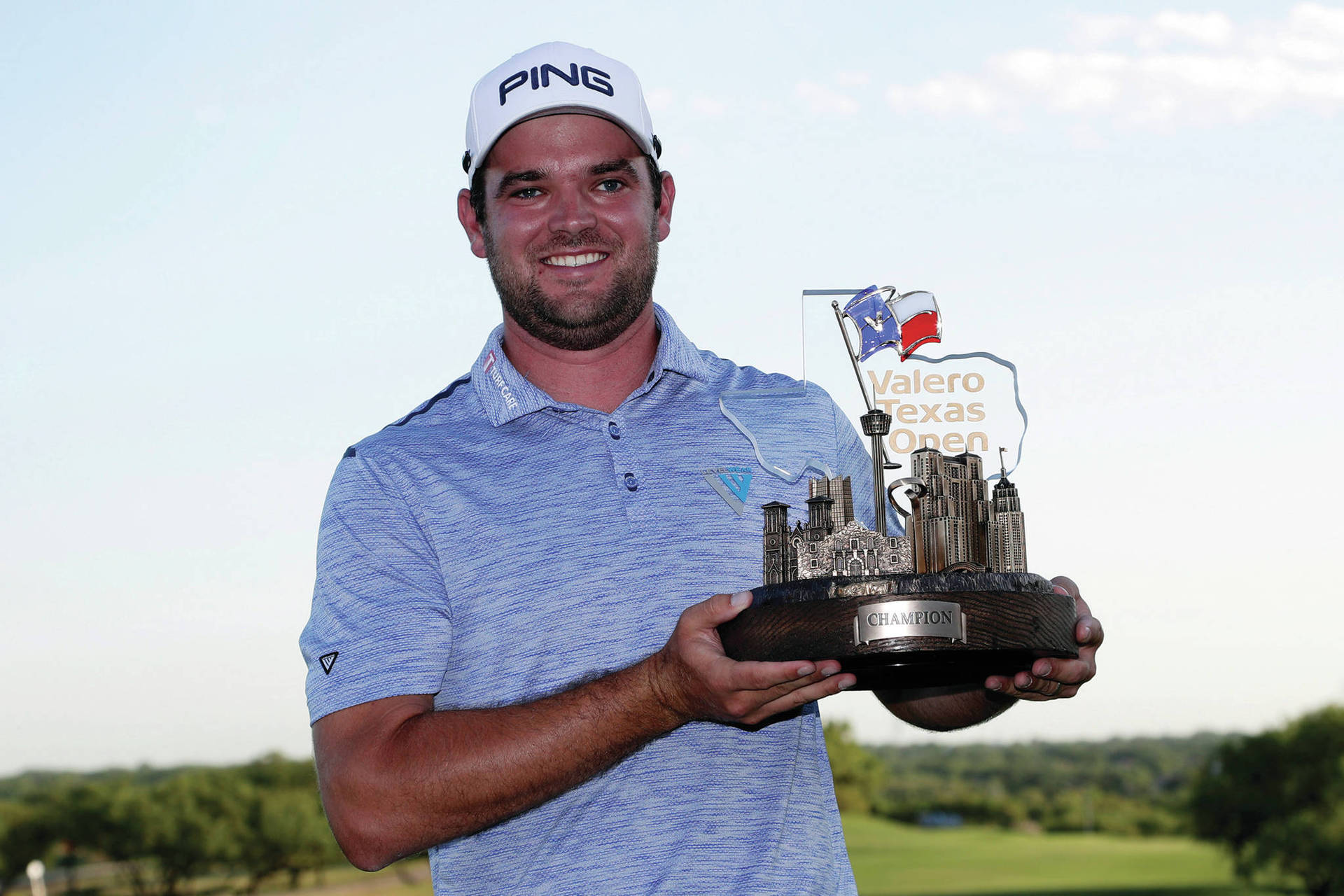 Corey Conners Holding A Trophy Background