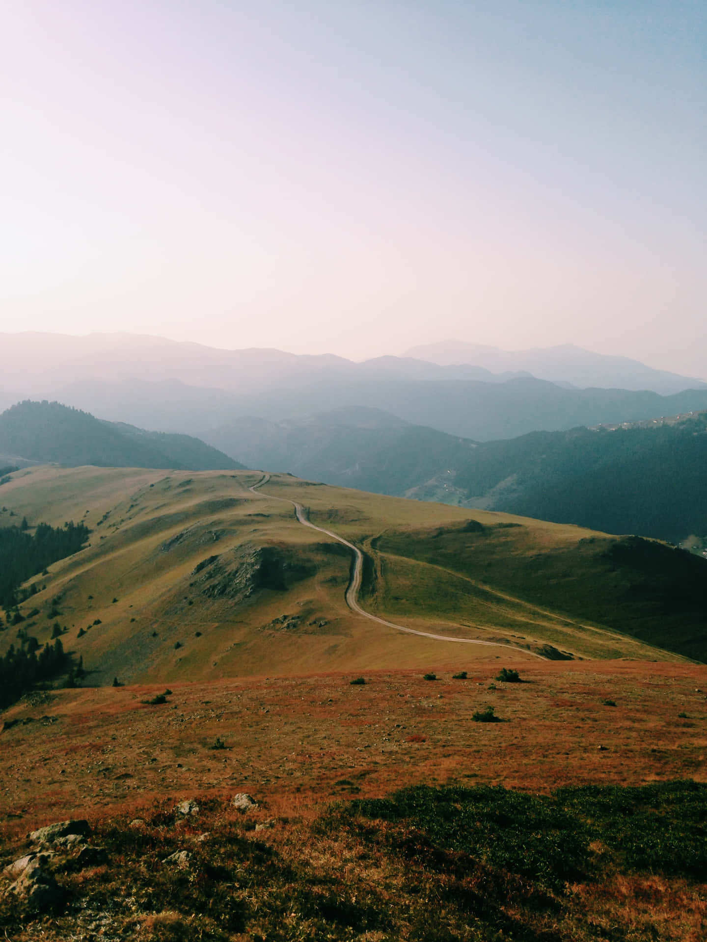 Country Road Between Brown And Green Hills Background