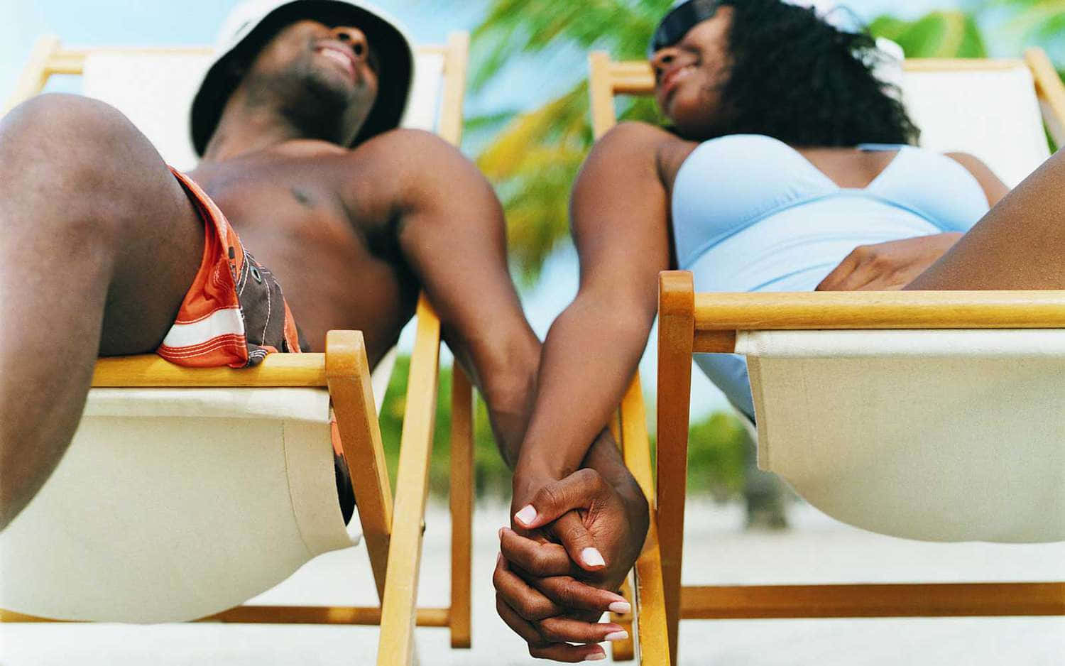 Couple At Beach On Reclining Chairs Background