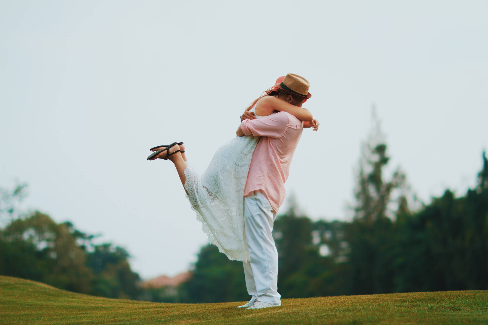 Couple Hugging In Catcher Hug On Green Landscape Background