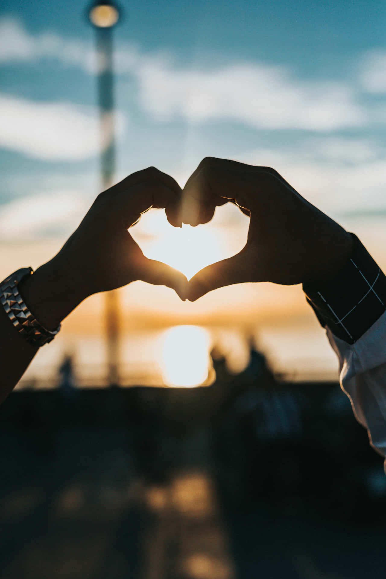 Couple Making A Heart Shape With Hands At Sunset