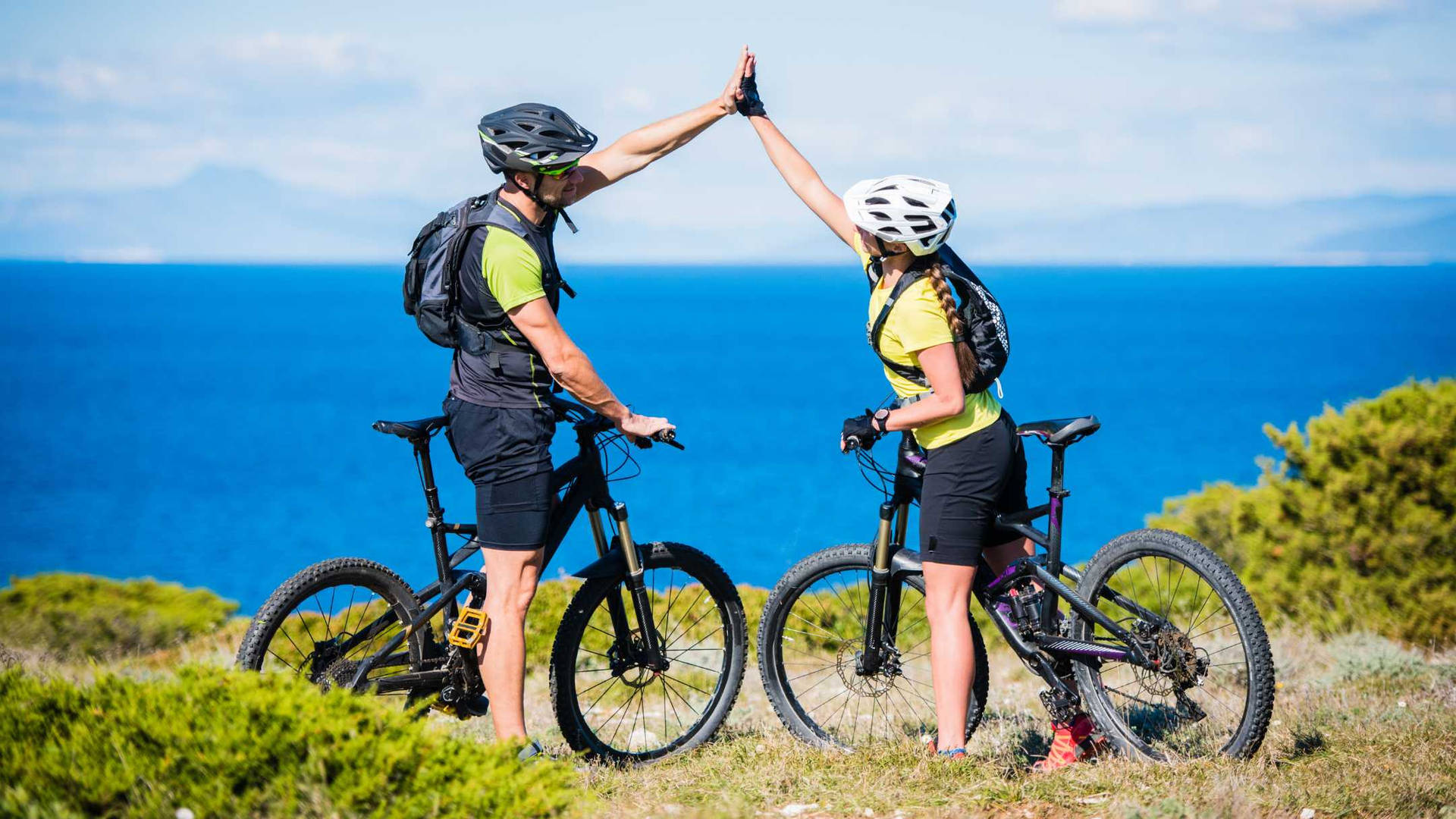 Couple Mountain Biking At Mountain Lake Background