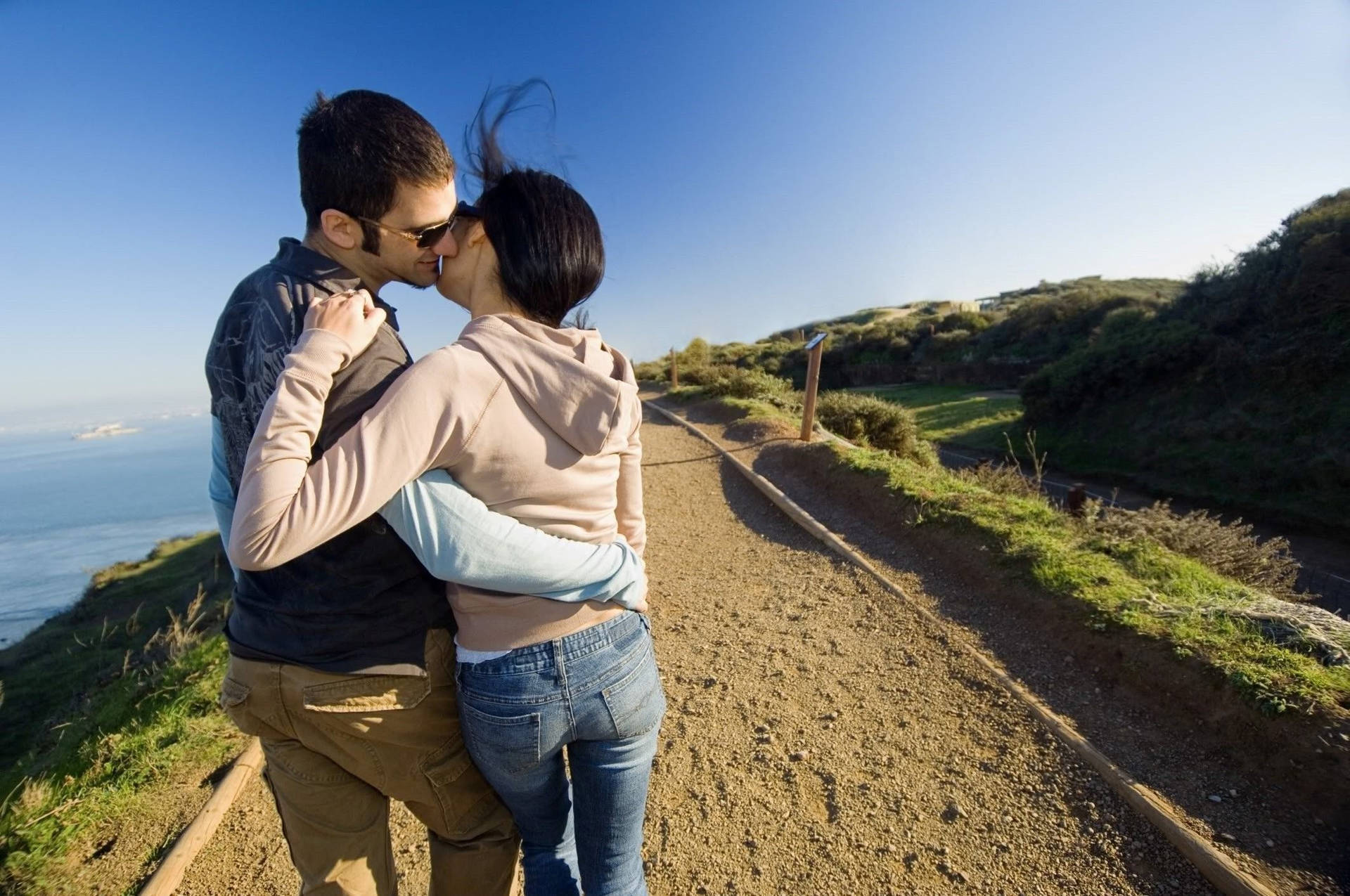 Couple's Romantic Love On A Hill Background