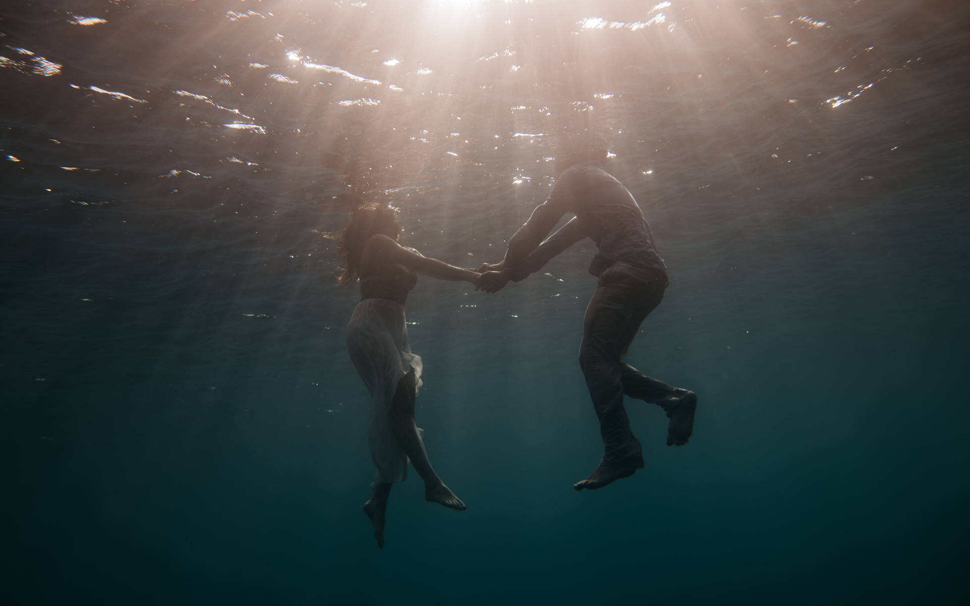 Couple Swimming Under The Ocean Background