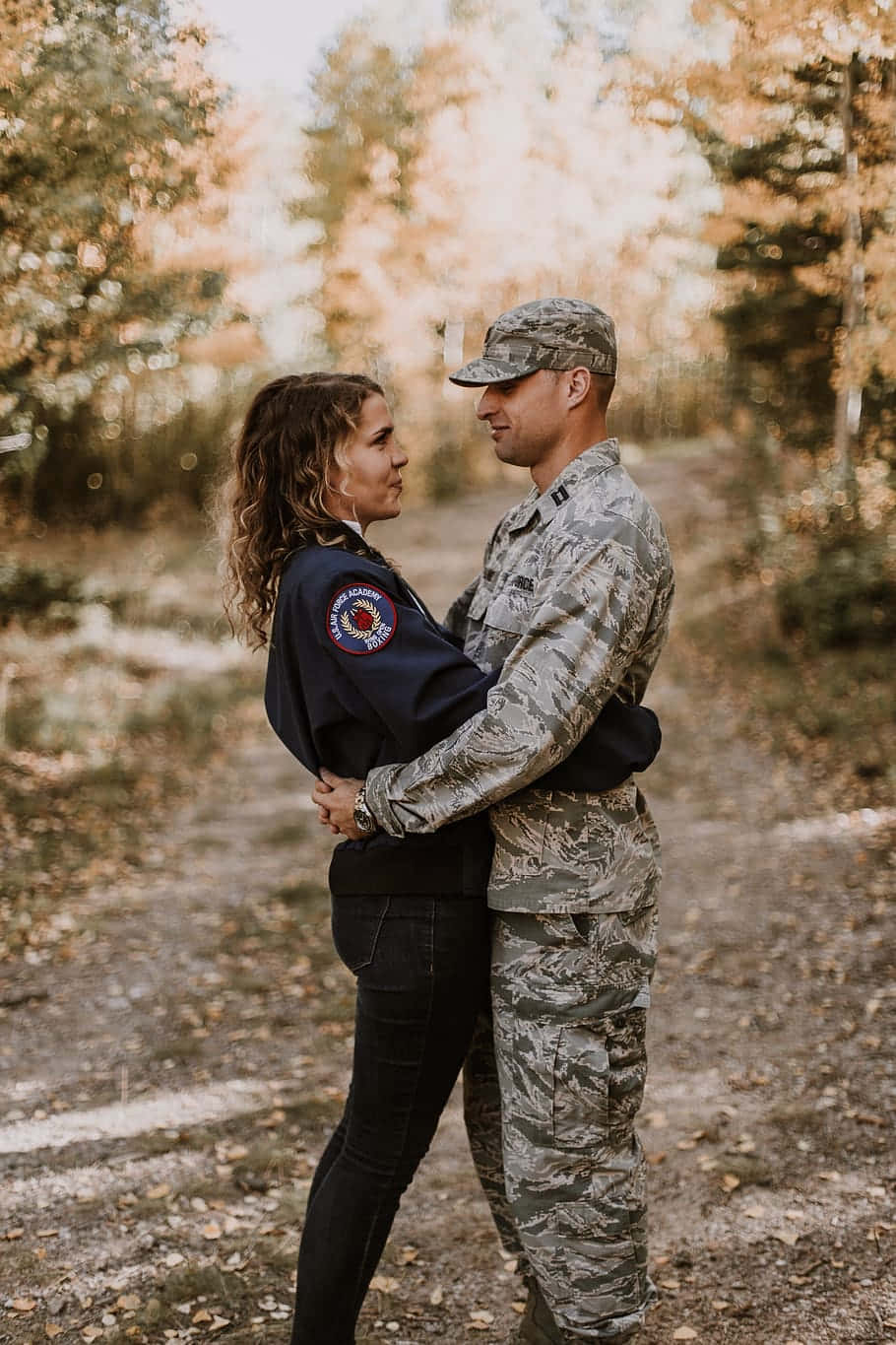 Couple Wearing Military Uniform Hugging Background