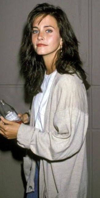 Courteney Cox Effortlessly Gripping A Bottle Background