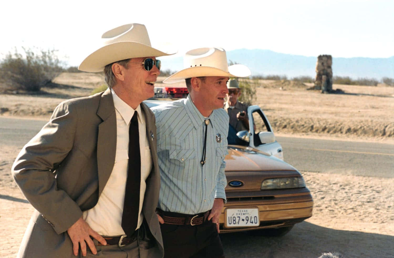 Cowboy Hatted Men Walking Beside Car Background