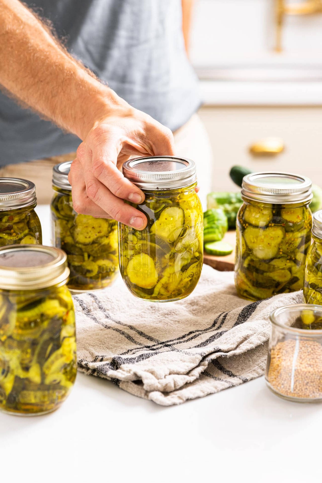 Crispy Pickle Slices With Silver Jar Lid Background