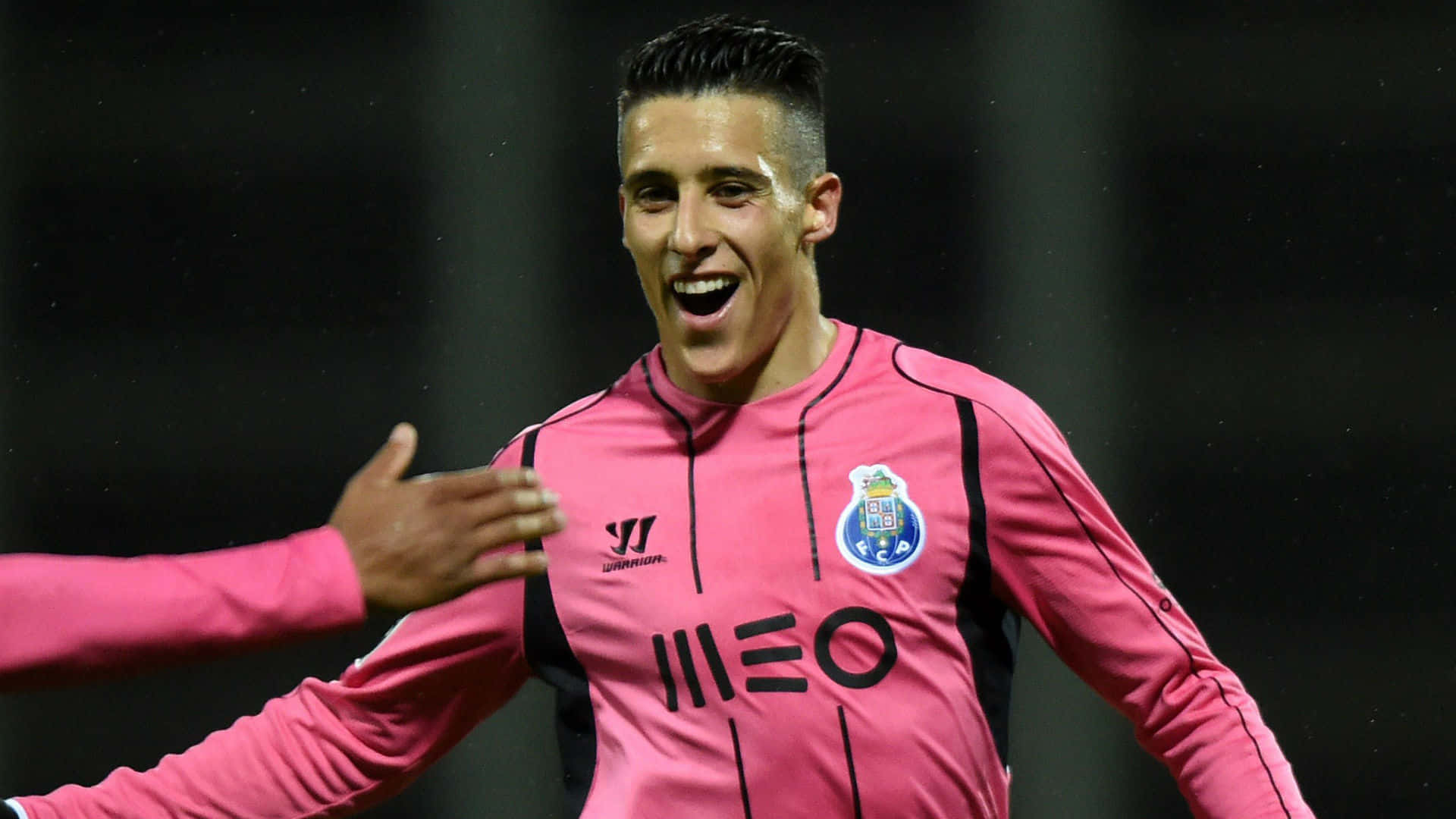 Cristian Tello Celebratingin Pink Jersey Background