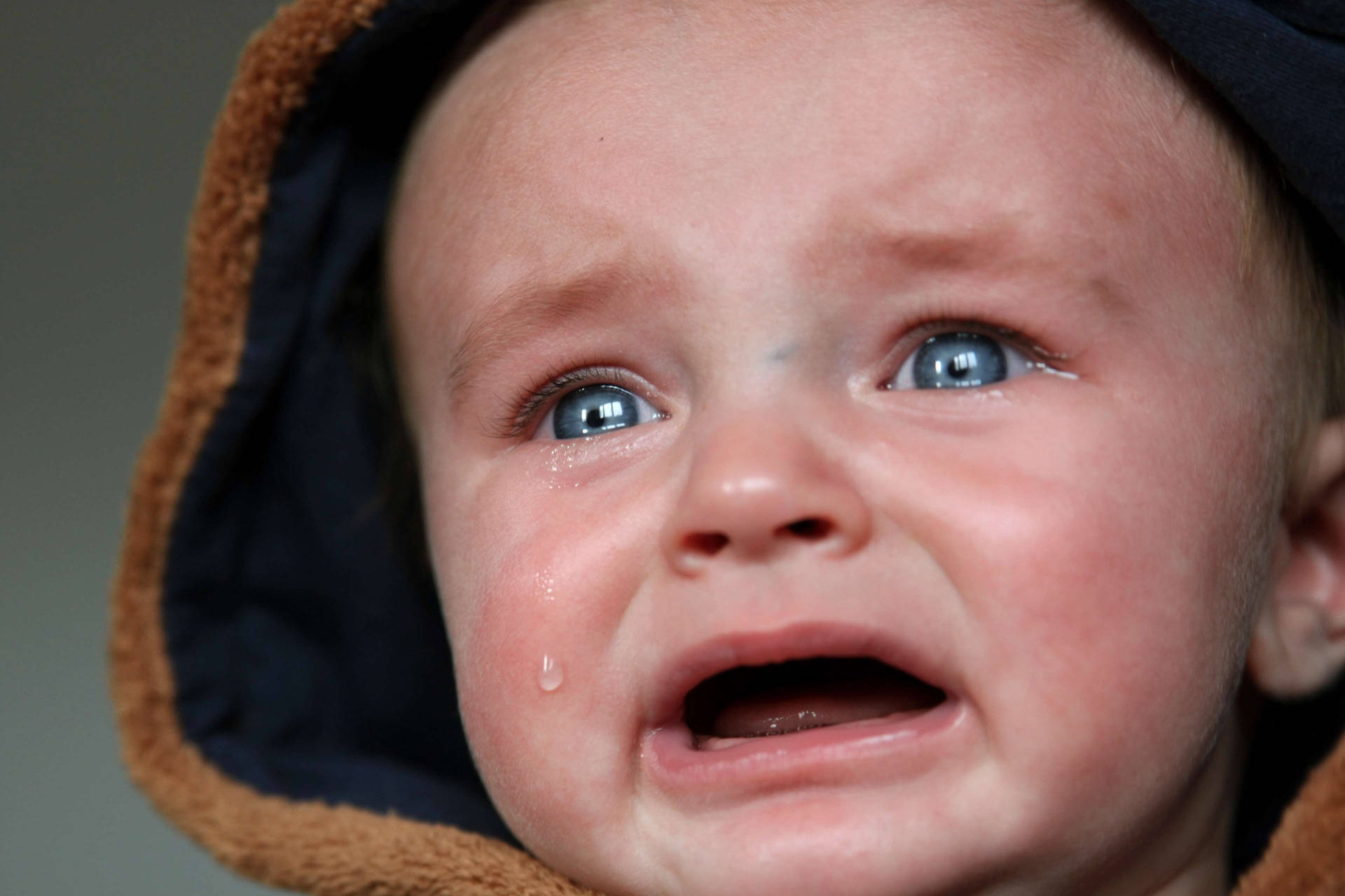 Crying Funny Baby With Blue Eyes Background