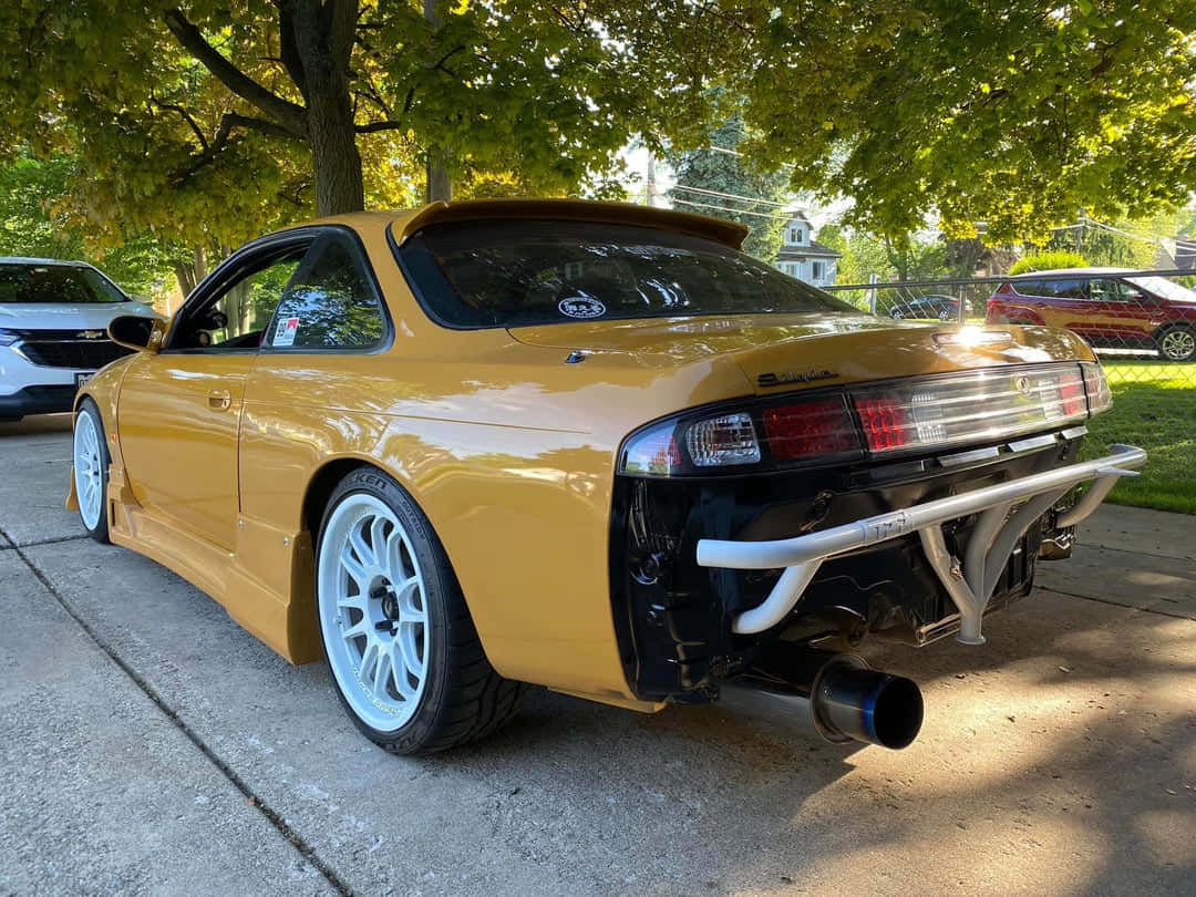 Customized Yellow Nissan240sx Parked Outdoors Background