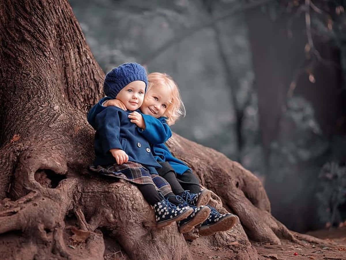 Cute Baby Couple Hugging Under The Tree Background