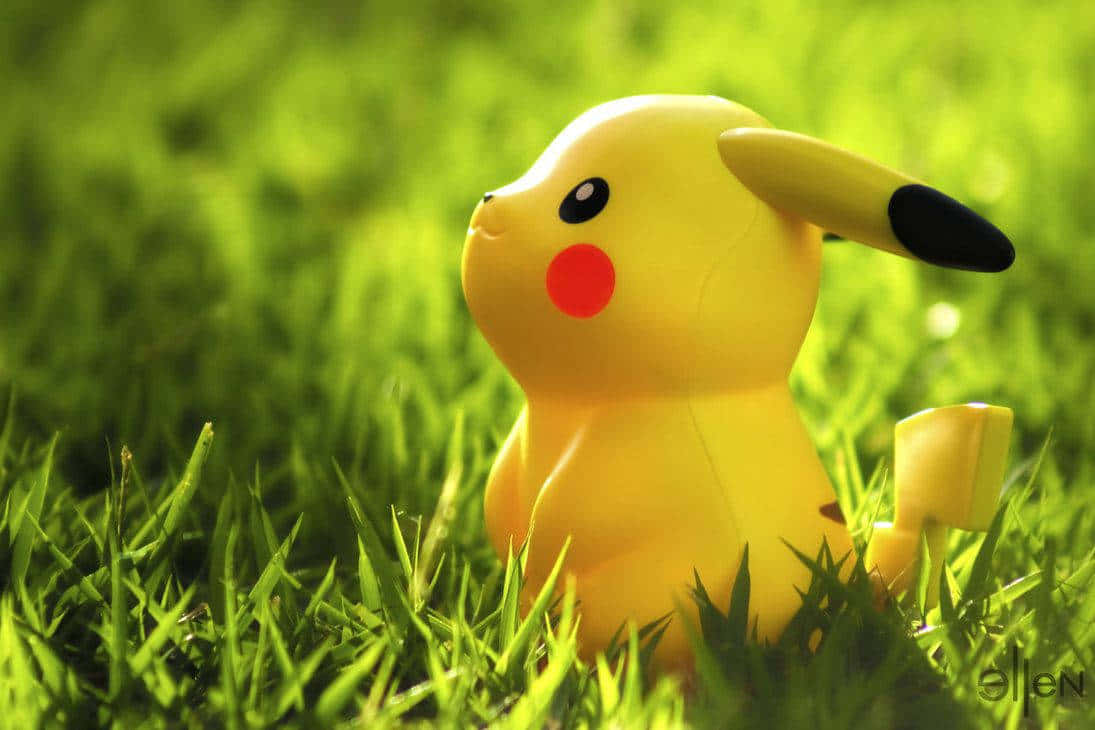 Cute Baby Pikachu Toy In Grass Background