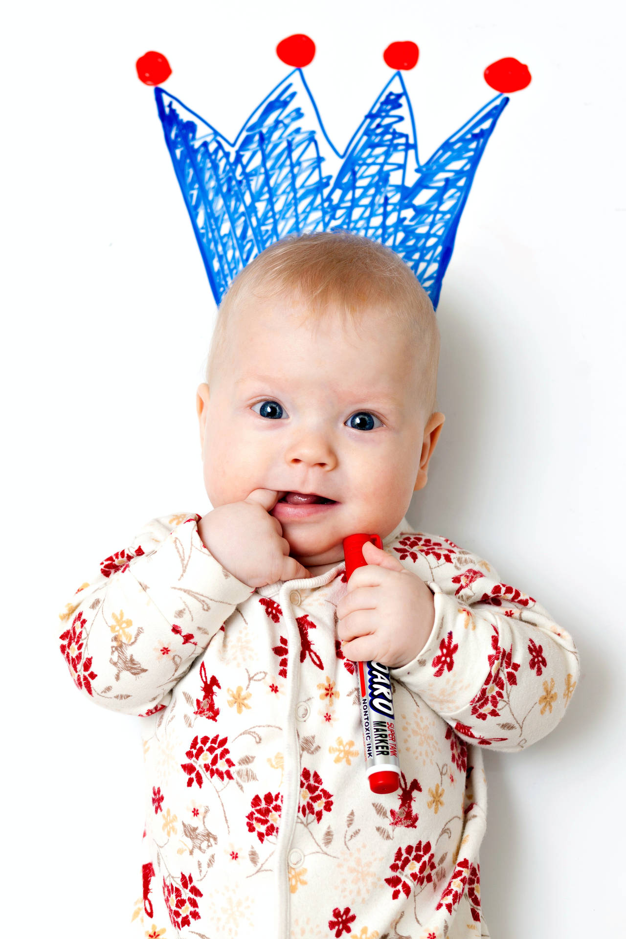Cute Baby Portrait With Blue Crown Doodle Background