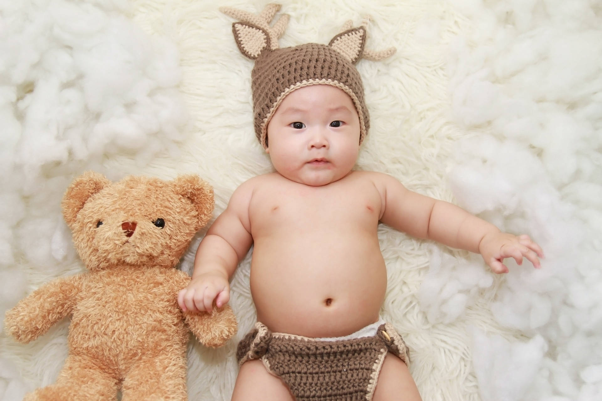 Cute Baby With Knitted Hat And Stuffed Bear