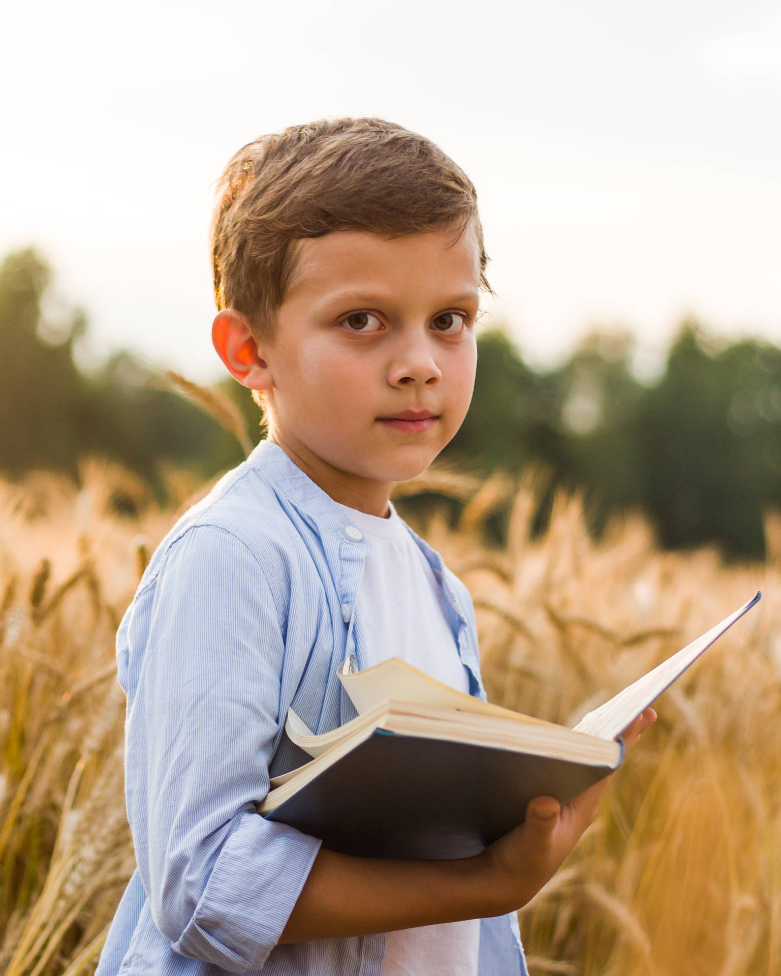 Cute Boy Standing With Open Book Background