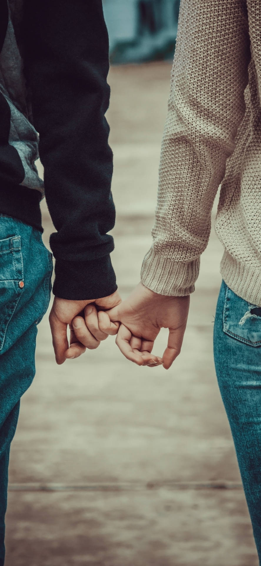 Cute Holding Hands Couple In Sweatshirts Background