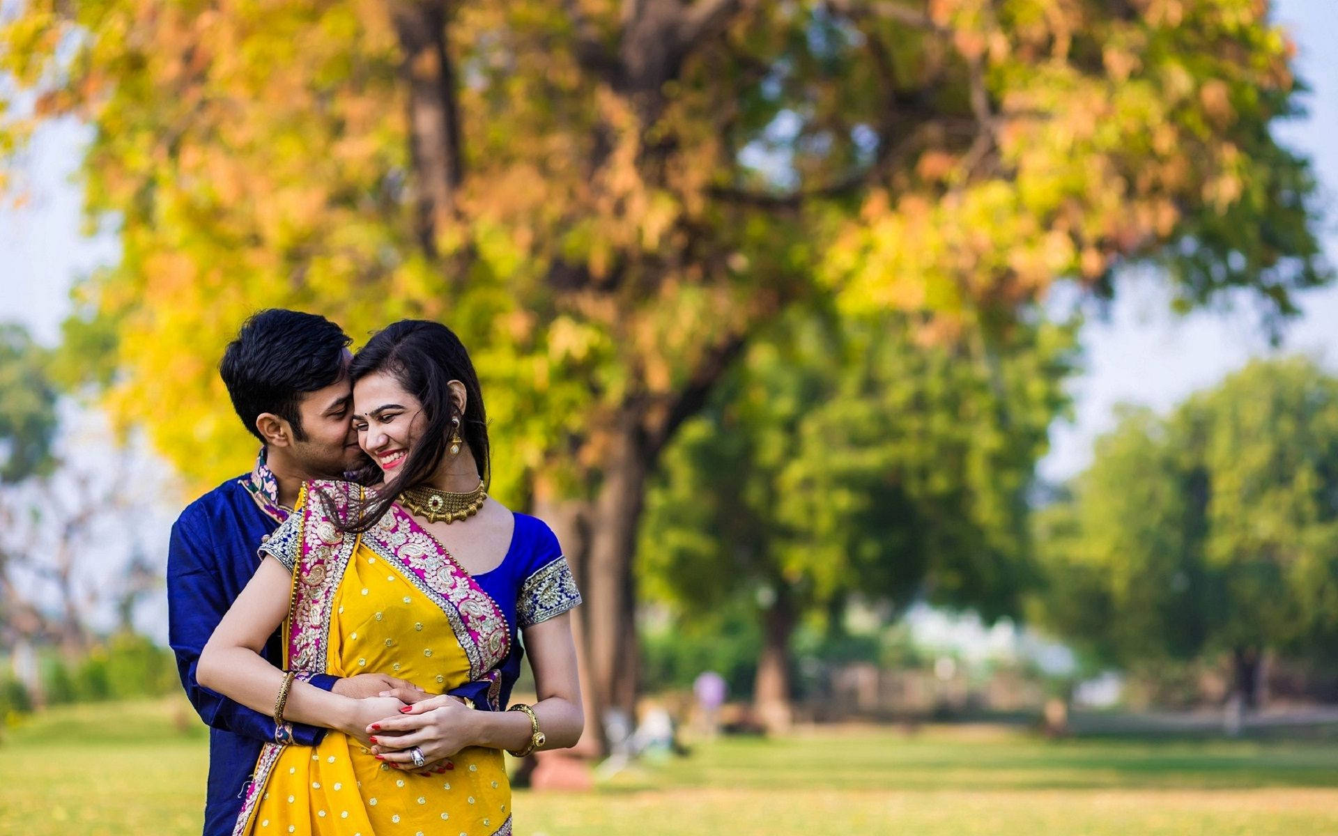 Cute Indian Couple In Wedding Attire At Park Background