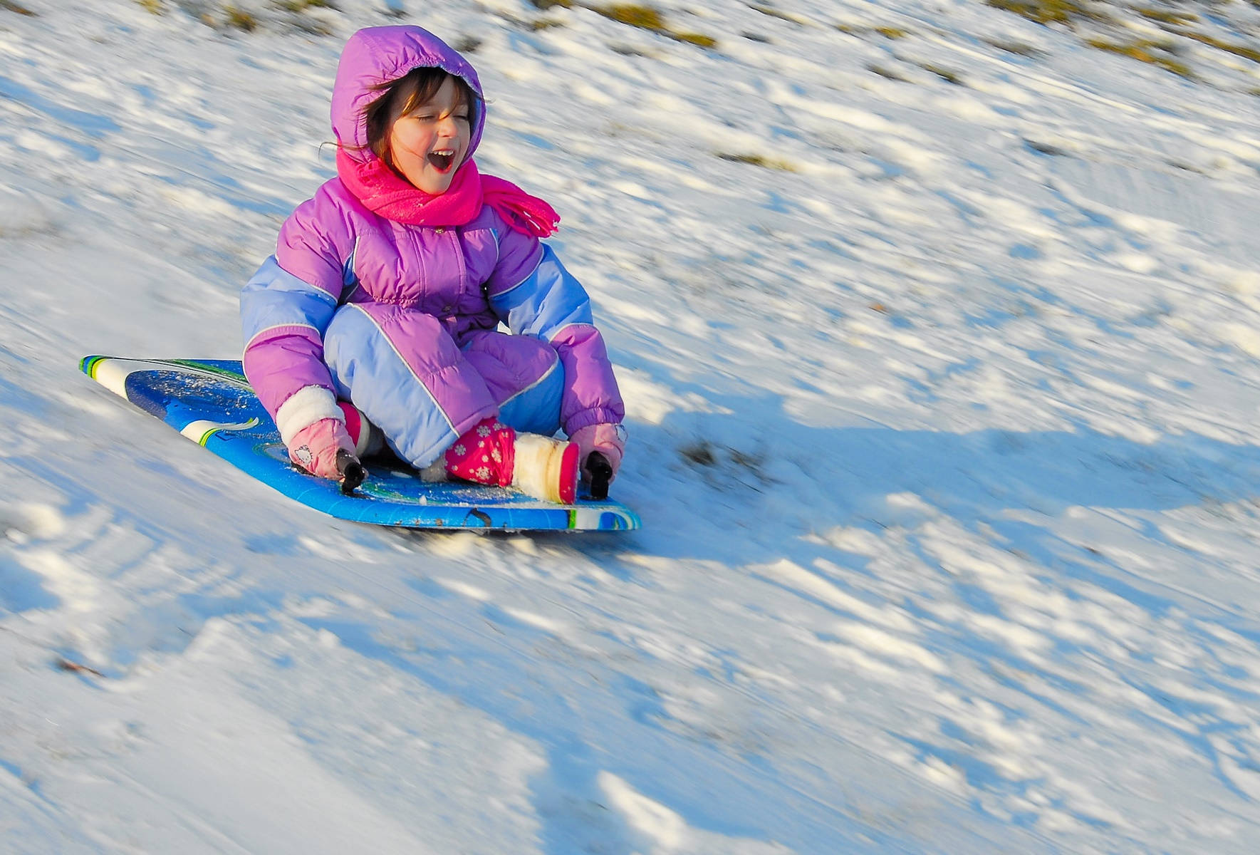 Cute Little Girl Sledding At Snow