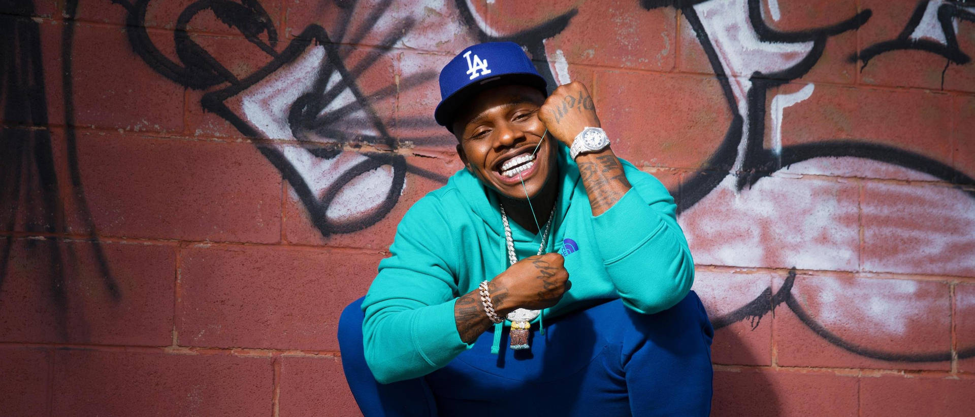 Dababy In Teal Jacket Outfit Background