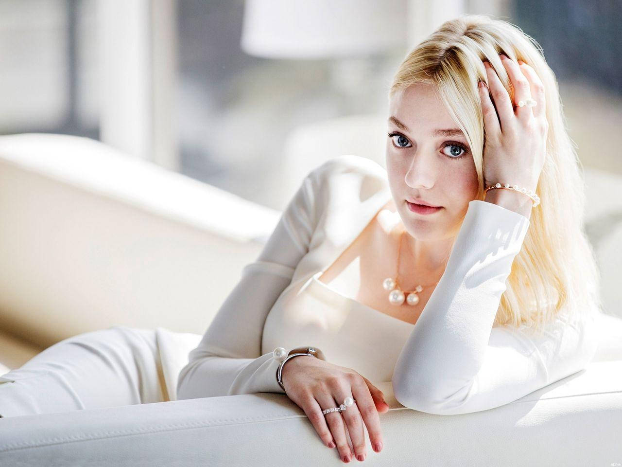 Dakota Fanning Relaxes On Couch Background