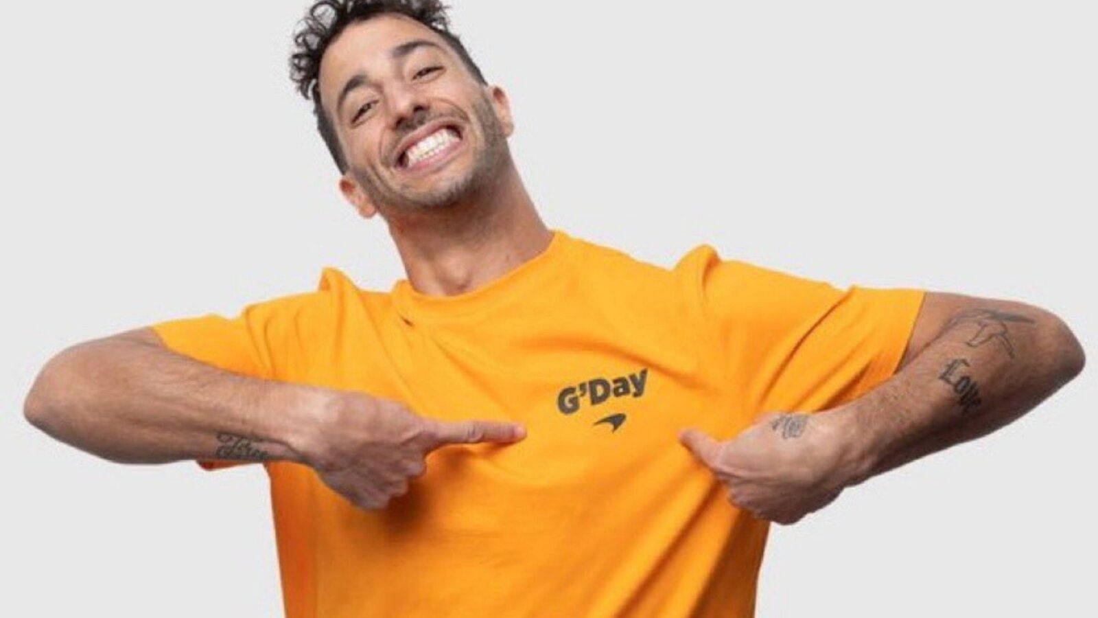 Daniel Ricciardo Posing In An Orange 'g'day' Shirt Background