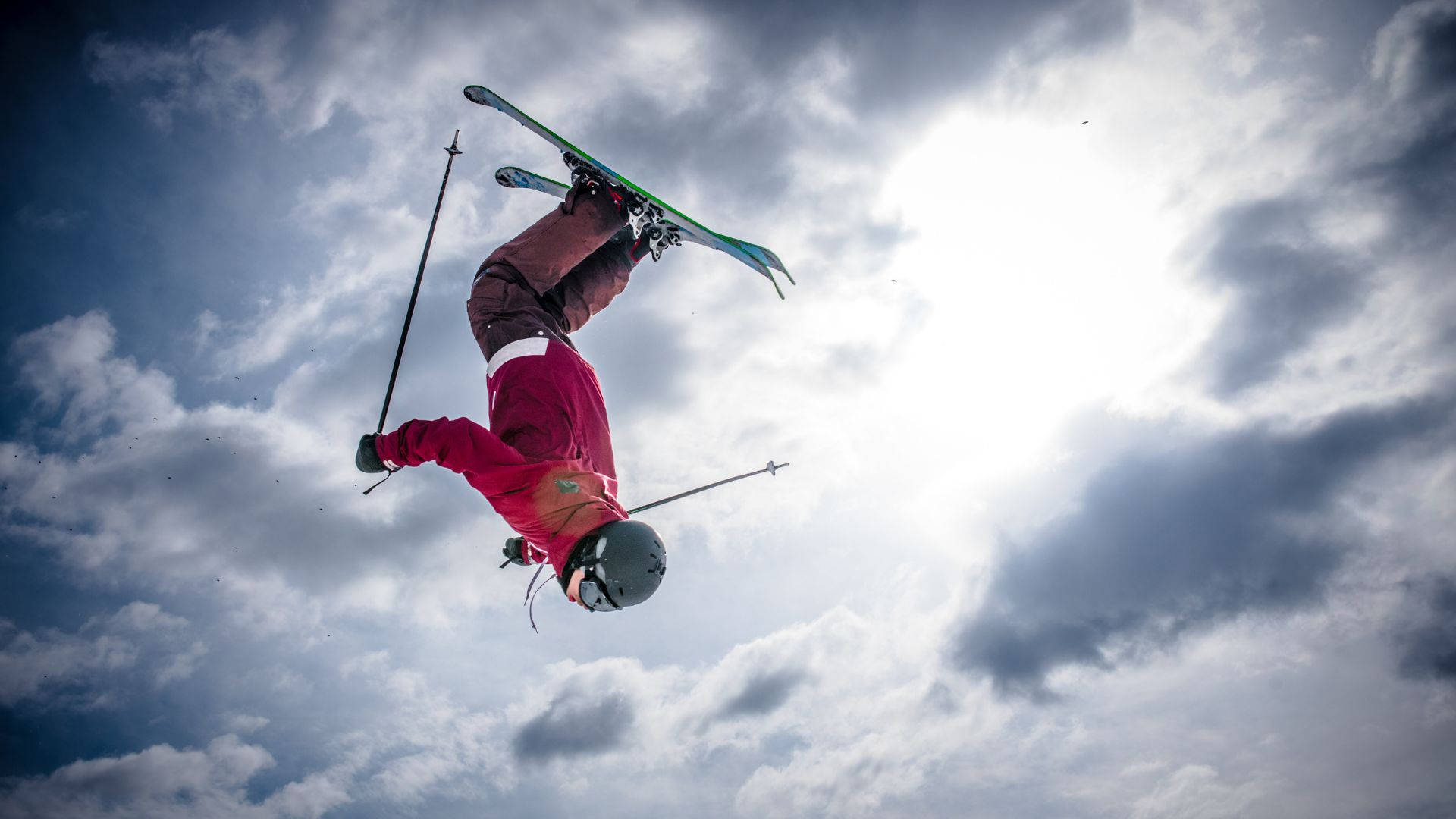 Daredevil Ski Jumper Performing A High-flying Backflip Background