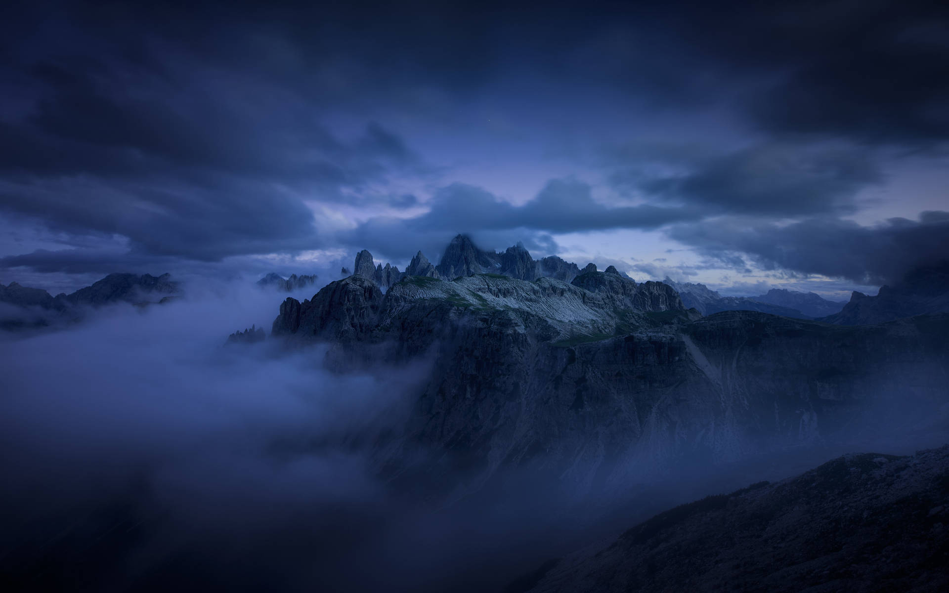 Dark Blue Clouds Hanging Over Mountains Background