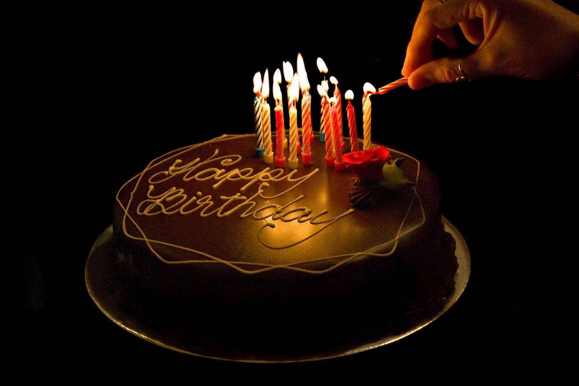 Dark Chocolate Birthday Cake Adorned With Lit Candles Background