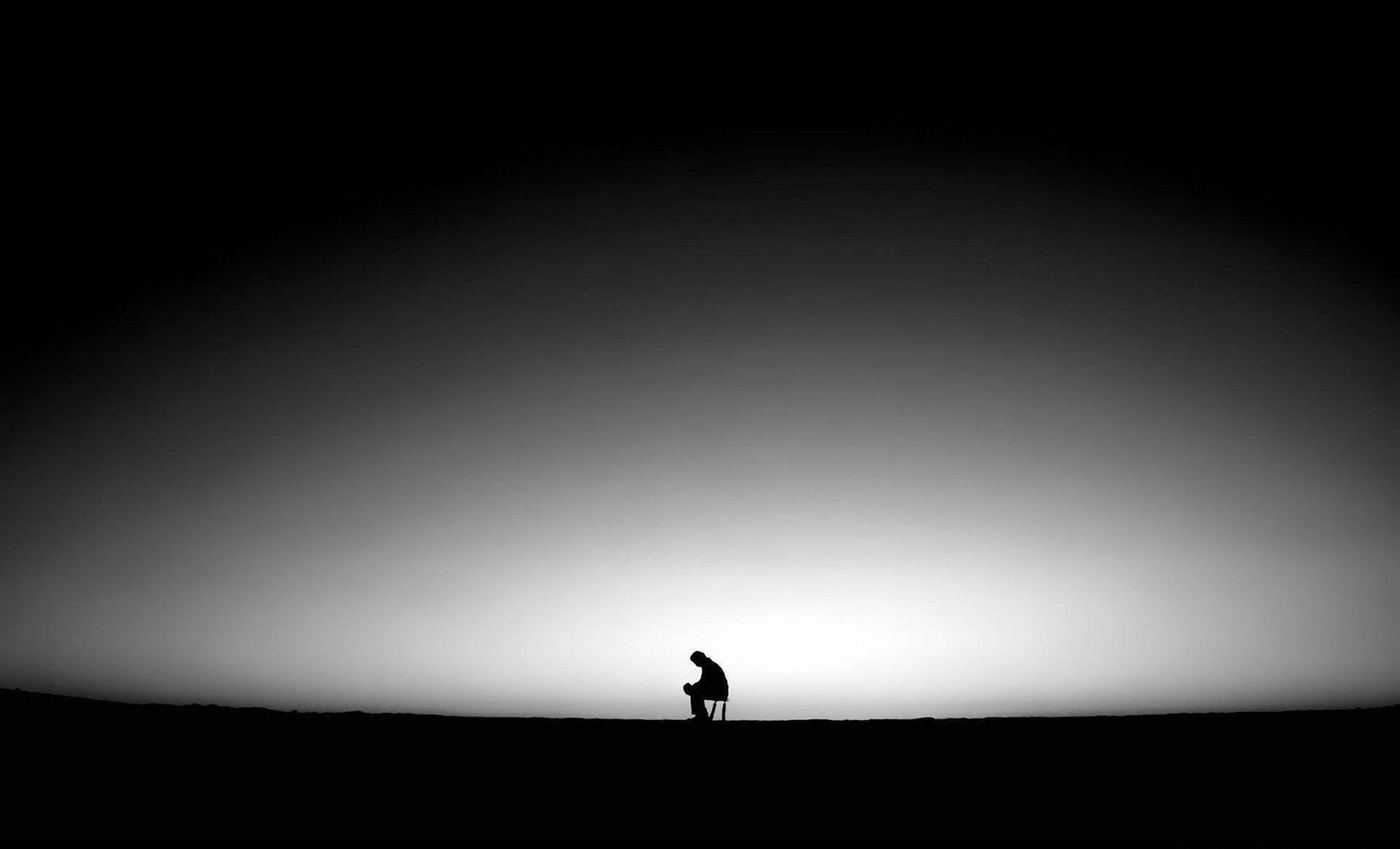 Dark Sad Man Seated On Stool Background