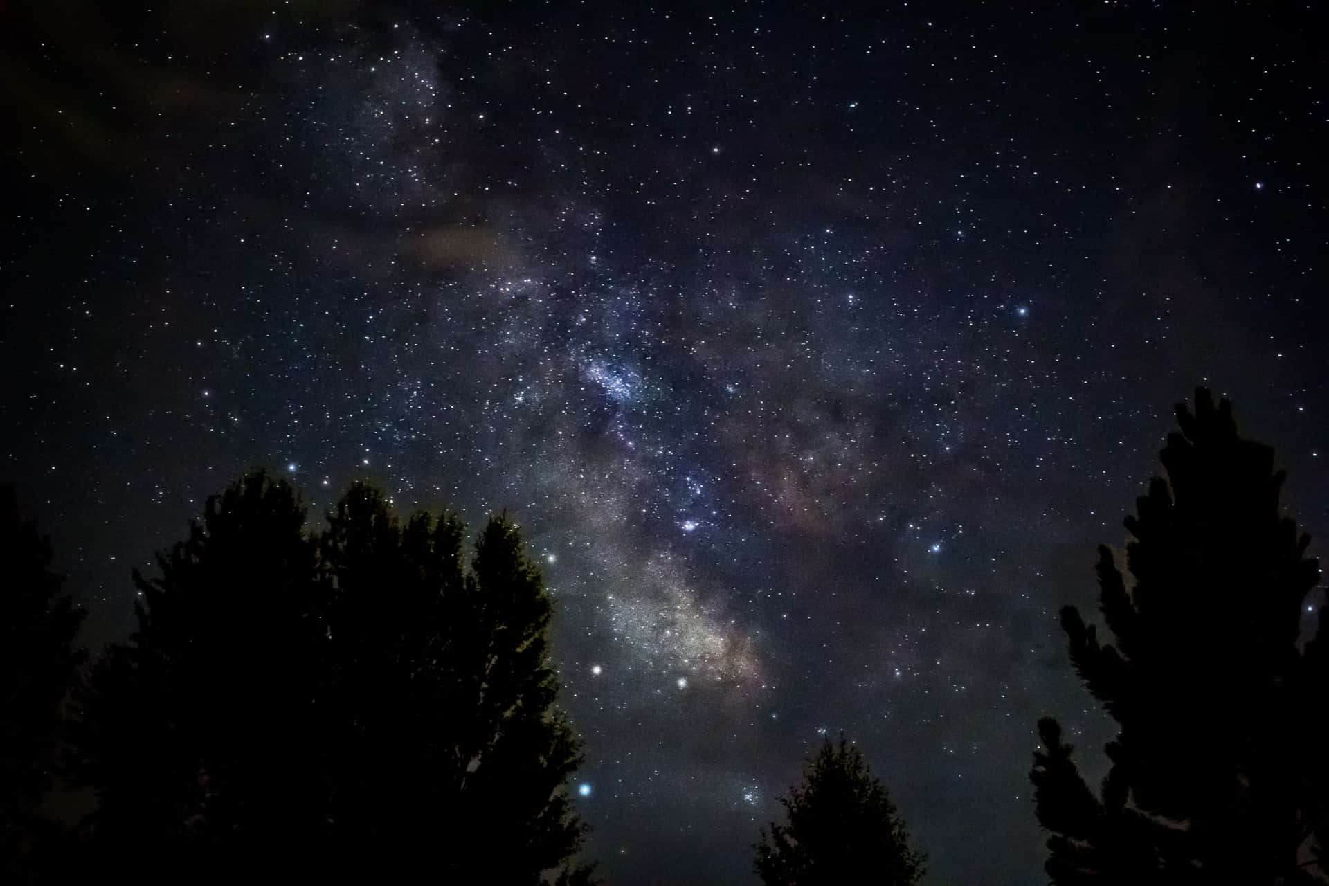 Dark Starry Night Over A Rocky Landscape Background