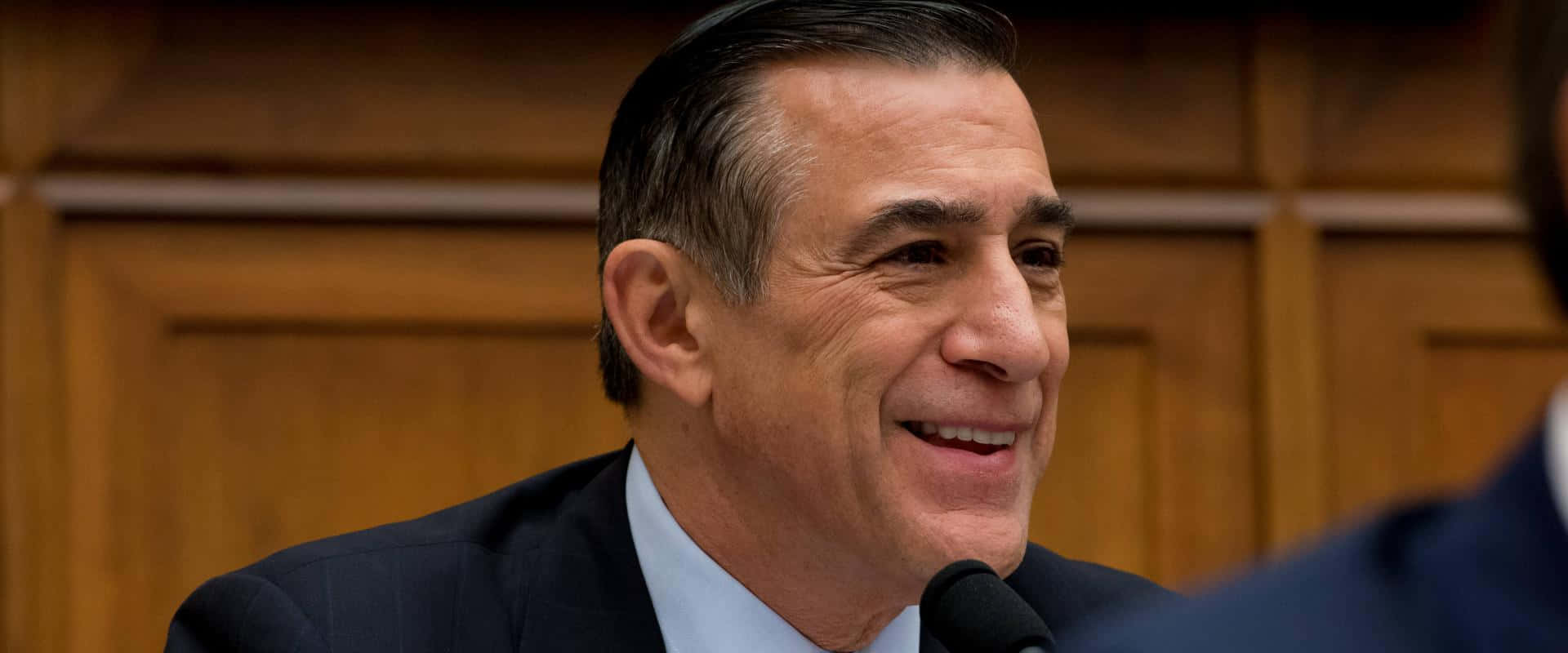 Darrell Issa Smiling Against Wooden Wall Background