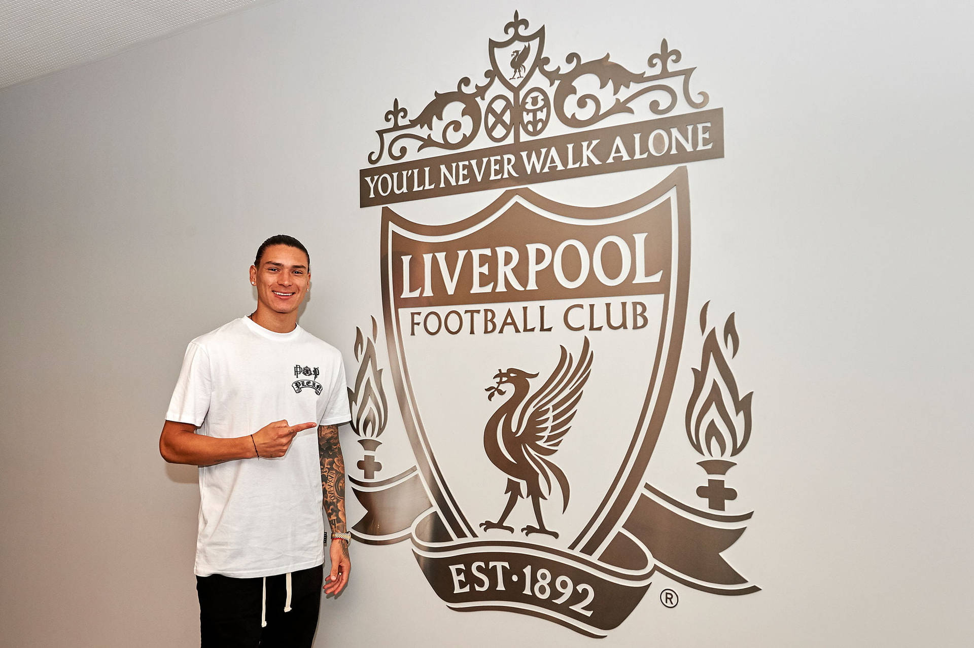 Darwin Núñez Pointing Liverpool Crest Background