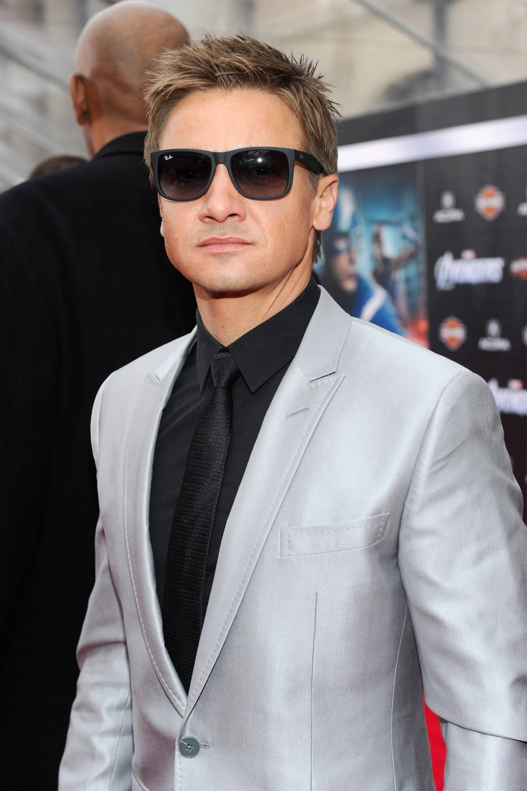 Dashing Hollywood Star Jeremy Renner Dressed In Silver Suit Background