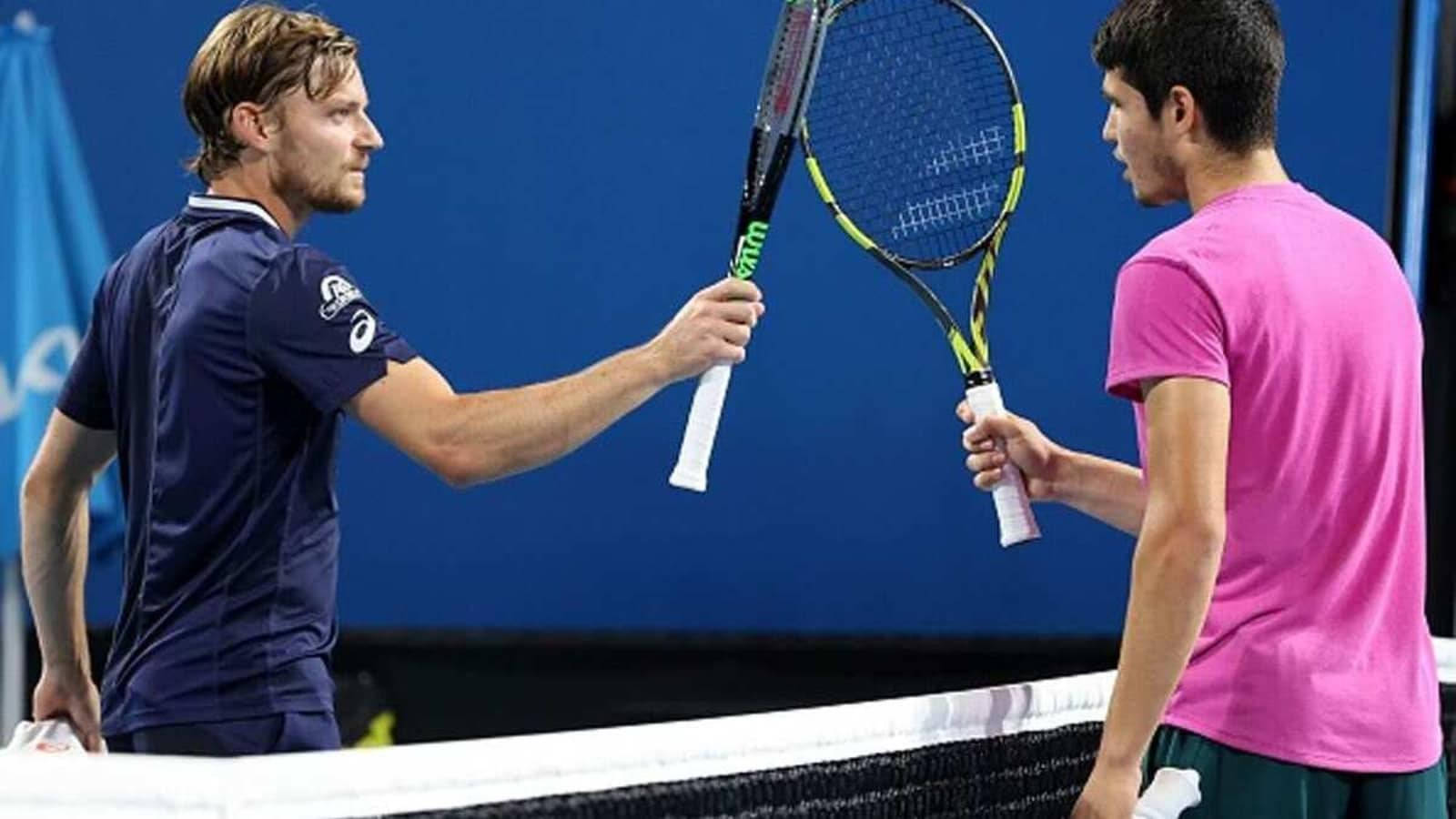 David Goffin In Action Against Carlos Alcaraz During A Tennis Match. Background