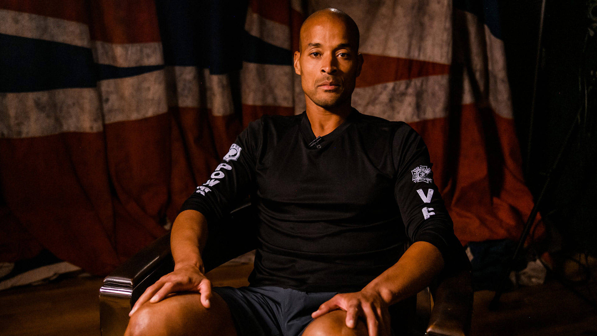 David Goggins Posing In Chair Background